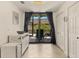 Hallway featuring tile floors leading to a patio with outdoor seating, accessible through sliding glass doors at 6611 Grand Estuary Trl # 105, Bradenton, FL 34212