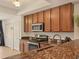Kitchen with granite countertops, stainless steel microwave and stove and wooden cabinets at 6611 Grand Estuary Trl # 105, Bradenton, FL 34212