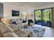 Inviting living room featuring a comfy reclining sofa, ceiling fan and a sliding glass door out to the screened lanai at 6611 Grand Estuary Trl # 105, Bradenton, FL 34212