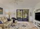 Bright living room featuring a ceiling fan, neutral colors, comfortable seating, and a sliding glass door to the screened porch at 6611 Grand Estuary Trl # 105, Bradenton, FL 34212
