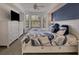 Comfortable bedroom featuring a ceiling fan, stylish decor, and a large window letting in plenty of natural light at 6611 Grand Estuary Trl # 105, Bradenton, FL 34212