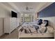 Bright bedroom featuring a bay window, dark blue accent wall, and white furniture at 6611 Grand Estuary Trl # 105, Bradenton, FL 34212