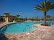Enjoy this large community pool with brick patio and palm tree under clear blue skies at 6611 Grand Estuary Trl # 105, Bradenton, FL 34212