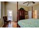 Bedroom with a four-poster bed, wood floors, and a door to the outside at 6619 Copper Ridge Trl, Bradenton, FL 34201