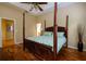 Bedroom with a four-poster bed, hardwood floors, ceiling fan and ensuite bathroom at 6619 Copper Ridge Trl, Bradenton, FL 34201