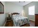 Cozy bedroom with a queen bed, a wooden side table, and a window with blinds at 6619 Copper Ridge Trl, Bradenton, FL 34201