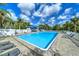 Community pool with bright blue sky surrounded by lounge chairs and greenery at 6619 Copper Ridge Trl, Bradenton, FL 34201
