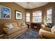 Cozy living room featuring a comfortable sofa, desk, and natural light from multiple windows at 6619 Copper Ridge Trl, Bradenton, FL 34201