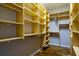Spacious walk-in closet with custom shelving and hardwood floors at 6619 Copper Ridge Trl, Bradenton, FL 34201