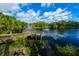 Scenic waterfront view with private dock access, lush greenery, and boat on a sunny day at 6619 Copper Ridge Trl, Bradenton, FL 34201