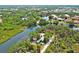 Scenic aerial view of a waterfront property, showing a vibrant home surrounded by mature trees and beautiful water views at 6737 Lincoln Rd, Bradenton, FL 34203