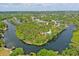 Aerial view of a waterfront home on a private lot, surrounded by lush greenery and stunning water features at 6737 Lincoln Rd, Bradenton, FL 34203
