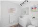 Bright bathroom featuring a new vanity, mirror, toilet, lighting and wainscotting at 6737 Lincoln Rd, Bradenton, FL 34203
