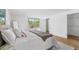 Bright bedroom featuring a bed, light wood floors, a window overlooking lush outdoor scenery, and access to a walk-in closet at 6737 Lincoln Rd, Bradenton, FL 34203