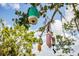 Unique yard decor hanging in the tree create whimsical charm to the outdoor space and ambiance at 6737 Lincoln Rd, Bradenton, FL 34203