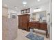 Bathroom featuring a unique stone vessel sink, carved wood vanity, and tiled shower at 6820 19Th W Ave, Bradenton, FL 34209