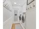 Bright laundry room with full-size washer and dryer, wainscoting and trim, and access door at 6820 19Th W Ave, Bradenton, FL 34209