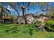 Charming home exterior featuring a well-maintained lawn and beautiful mature shade trees at 6946 Woodwind Dr # 2, Sarasota, FL 34231