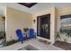 Inviting front entrance with blue Adirondack chairs and well-maintained landscaping at 6946 Woodwind Dr # 2, Sarasota, FL 34231