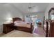 Bright bedroom featuring a ceiling fan, wood furniture, and access to a private outdoor patio at 6946 Woodwind Dr # 2, Sarasota, FL 34231
