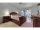 Bright bedroom featuring a ceiling fan, wood furniture, and access to a private outdoor patio at 6946 Woodwind Dr # 2, Sarasota, FL 34231