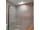 Updated tiled shower with glass door and modern fixtures at 6946 Woodwind Dr # 2, Sarasota, FL 34231