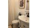 A bathroom featuring a white toilet, sink with vintage-style faucet, and a shower with white curtain at 7036 Clark Rd, Sarasota, FL 34241