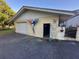 An exterior view of the property's garage with two garage doors and a pedestrian door at 7036 Clark Rd, Sarasota, FL 34241