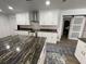 Modern kitchen with white cabinets, granite countertops, stainless steel appliances, and hardwood floors at 7036 Clark Rd, Sarasota, FL 34241