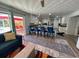 Bright, open kitchen with white cabinets, center island, and bar seating extending to an open doorway to the outdoor patio at 7036 Clark Rd, Sarasota, FL 34241