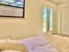 Serene bedroom with natural light, cozy bed and glass doors to backyard at 7314 Mauna Loa Blvd, Sarasota, FL 34241