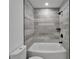 Modern bathroom features a bathtub with stylish gray tile surround and matte black fixtures at 732 15Th E St, Bradenton, FL 34208