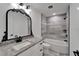 Modern bathroom with gray tiling in the shower and flooring, vanity, and black hardware at 732 15Th E St, Bradenton, FL 34208