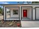 Inviting front porch features a bright red door, black trim, and fresh landscaping at 732 15Th E St, Bradenton, FL 34208