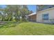 Backyard view with screened porch, lush lawn, and mature trees at 7687 Sweetbay Cir # 7687, Bradenton, FL 34203