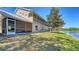 A lush backyard featuring a screened-in patio, a view of a serene pond, and green lawn at 7687 Sweetbay Cir # 7687, Bradenton, FL 34203