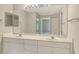 Well-lit bathroom with a double sink vanity, large mirror, and ample cabinet space for storage at 7687 Sweetbay Cir # 7687, Bradenton, FL 34203