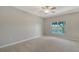 Spacious bedroom featuring plush carpeting, a ceiling fan, and a window overlooking a serene lake at 7687 Sweetbay Cir # 7687, Bradenton, FL 34203