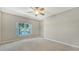 Bedroom featuring plush carpet, a ceiling fan, and a scenic lake view window at 7687 Sweetbay Cir # 7687, Bradenton, FL 34203