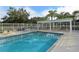 Community pool features sunbathing chairs and shaded area with tables for residents at 7687 Sweetbay Cir # 7687, Bradenton, FL 34203