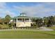 Exterior view of a clubhouse with a green roof, porch, and manicured lawn at 7687 Sweetbay Cir # 7687, Bradenton, FL 34203