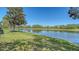 Peaceful pond view framed by mature trees, with a golf course in the distance at 7687 Sweetbay Cir # 7687, Bradenton, FL 34203