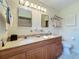Bathroom featuring a double sink vanity, framed mirrors, decorative elements, and a towel rack above the toilet at 7810 San Juan Ave, Bradenton, FL 34209