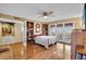 Bright bedroom with hardwood floors, balcony access, ceiling fan, and built-in bookshelves at 835 S Osprey Ave # 415, Sarasota, FL 34236