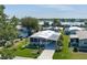 Aerial view of a community with single-story homes, palm trees, and a beautiful waterfront view at 8402 Princess Ct, Palmetto, FL 34221