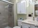 Bathroom featuring a shower with glass doors, a tiled shower, and a white vanity cabinet with an overhead cabinet at 8402 Princess Ct, Palmetto, FL 34221
