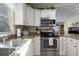 Well-lit kitchen featuring stainless steel appliances, white cabinets, and ample countertop space at 8402 Princess Ct, Palmetto, FL 34221