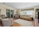 Comfortable living room with plush seating, wood-look floors, and natural light from the windows at 8402 Princess Ct, Palmetto, FL 34221