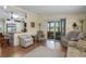 Spacious living room with wood-look flooring, comfortable seating, and a seamless flow to the kitchen at 8402 Princess Ct, Palmetto, FL 34221