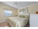 Serene main bedroom with a floral-patterned bedspread, white furniture, and a ceiling fan at 8402 Princess Ct, Palmetto, FL 34221